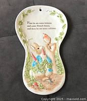 Full view of spoon rest showing relief scene, quote, and hanging hole