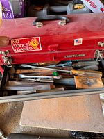 Closed Craftsman toolbox with top drawer showing screwdrivers, chisels, files