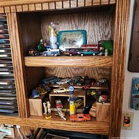 Overall view of both shelves showing quantity and variety of die-cast vehicles and accessories