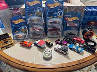 Overview of sealed Hot Wheels cards and loose diecast cars on table