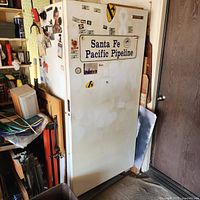 Full view of Kelvinator upright freezer with stickers on door