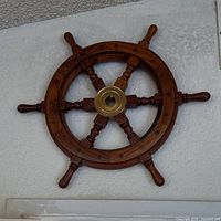 Wooden ship steering wheel mounted on wall
