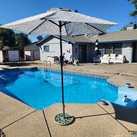 Full view of umbrella over pool showing canopy and pole