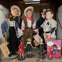 Large celebrity dolls and small fashion dolls on lower shelf