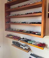 Wide view of wall-mounted shelves filled with diecast cars and trucks