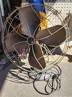 Front view of Emerson metal fan showing blades, cage, and base