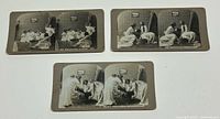 Three antique black and white Halloween stereoview cards showing children in white costumes playing bobbing for apples and a Halloween party intruder.