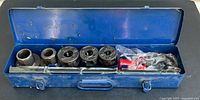 Blue metal case open showing pipe threader parts, dies, wrench and accessories inside.