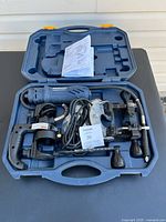 Open carrying case showing Mastercraft electric spin saw, power cord, attachments, and manual.