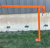 Side view of orange T-post fence puller tool showing long handle, vertical support, base plate, and hook mechanism at working end.