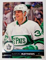 Front side showing Auston Matthews in St. Pats white and green jersey with helmet, Upper Deck logo visible.