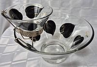 Photo showing front angled view of vintage chip and dip bowl set with black and gold leaf design and metal holder