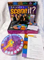 Game board laid out with DVDs, trivia cards, tokens, and instructions