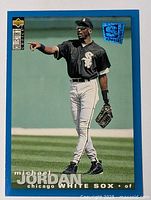 Close-up photo of a Michael Jordan baseball card in Chicago White Sox uniform with blue border and holographic sticker.