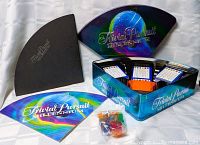 Full set of Trivial Pursuit Millennium Edition game components including game board, card holders with question cards, playing pieces in seal bag, instruction booklet, and box lid.