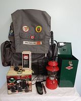 Full lot overview showing backpack, lanterns, coffee set boxes and grill