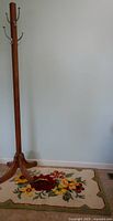 Full view of coat tree and rug against wall