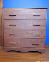 Front view of light brown four-drawer dresser