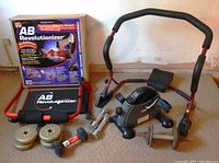 Overview showing Health Rider Mini Cycle, AB Revolutionizer frame and mat, retail box, dumbbells and weight plates