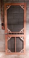 Front view of wooden screen door showing screen and decorative corner brackets
