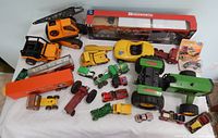 Group shot showing all items on table including boxed tractor-trailers, Tonka tractor and construction vehicles