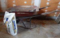 Side view of wheelbarrow and Quikrete bag