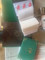 Green albums and brown album with plastic sleeves for photo, card, or coin collecting