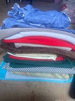 Stack of various fabric pieces in multiple colors including blue, red, brown, green, white, and patterned pieces.