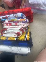 Folded fabric pieces showcasing assorted colorful prints including animal safari motifs and cartoon characters