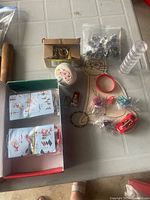 Photo showing various kids toys laid out including Lego instruction booklets, mini dolls, a bag of small figurines, a pack of key rings, clear plastic stacking tubes, and colorful tiny accessories.