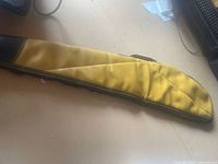 Side view of the tan leather case with zipper and brown leather trim detail.