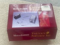 Closed box with Mercedes2000 logo and images showing manicure and pedicure tools included.