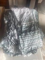 Photo of loosely folded queen size duvet cover and two pillow cases showing grey and white horizontal striped pattern.