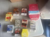 Photo showing 10 assorted wax melt packs in various brands and scents, displayed on white surface. Some packs have parts of wax missing.