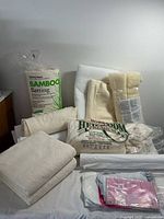 Photo of all batting materials including bamboo batting roll, Hobbs cotton batting, and folded batting pieces on a table.