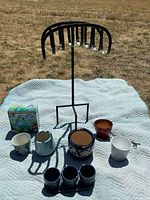 Lot displayed on light blue quilted mat outdoors, showing all ceramic planters, aqua globe watering bulbs box and metal hose hanger