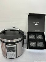 Photo showing Cosori electric cooking pot and open box containing five MG Home whiskey glasses.