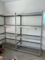 Two assembled steel shelving racks side by side against a garage wall