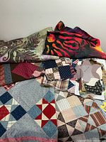 Multiple quilt blocks and fabric pieces on tabletop showing star and four-patch patterns