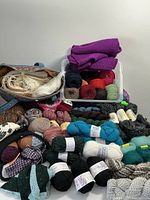 Overview of several yarn skeins and knitting projects showing colors and variety.