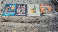 All four beer posters laid out side-by-side on ground