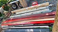 Stack of mixed metal and vinyl trim pieces with trailer background