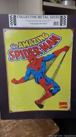 Front view of metal sign showing full Spider-Man artwork and header card
