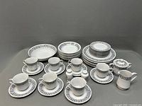Full set of Celebrity Matador china including bowls, plates, cups, saucers, sugar bowl, creamer, salt and pepper shakers arranged on gray background.