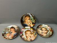 Overview of four collectible plates with Juan Ferrandiz artwork showing children and baby-themed illustrations.