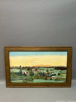 Front view of framed landscape oil painting on canvas showing rural houses, fields, and pond under a dusk sky with clouds.