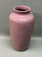 Full view of the tall pink pottery flower vase with a glossy finish.