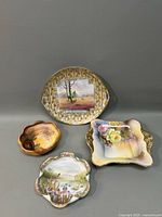 Four Nippon porcelain dishes and tray grouped together showing shape and artwork