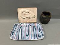 Full lot photo showing rams head plaque, Raku vase, and ceramic tray.