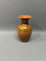 Front view of the Phoenix art glass vase showing iridescent orange and gold swirls and flared lip